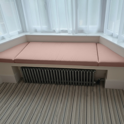 Cozy reading nook with soft pink window seat mattress set