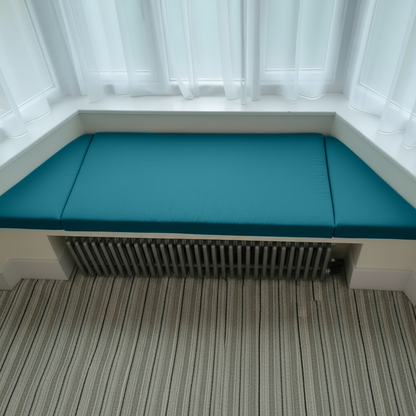 Elegant indoor seating with teal trapezoid bench pads and piping
