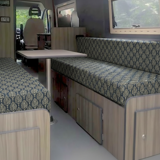 Luxury navy blue damask Campervan cushions interior-Elegant Block Print Style Upholstery on dining bench-Deep blue patterned motorhome seating with light wood-High density foam cushions with leaf motif-Sophisticated campervan conversion interior design