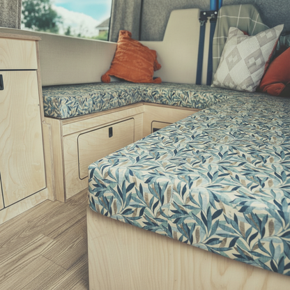 High-density caravan seating foam with modern fabric cover- Motorhome reupholstery interior with blue and green leaf design-Made-to-measure camper upholstery fitted in conversion van-Durable fabric texture for Motorhome bespoke furnishings

