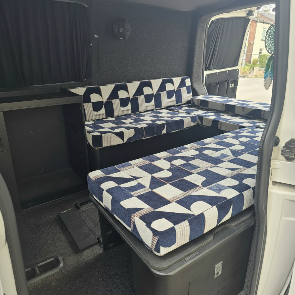 Navy blue and cream geometric pattern campervan cushions on a slide out bed system
