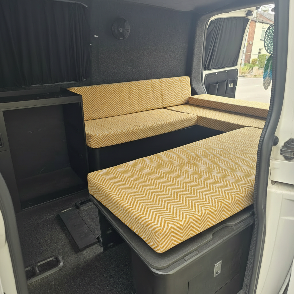 Premium campervan cushion seating with mustard yellow herringbone pattern on a slat bed system
