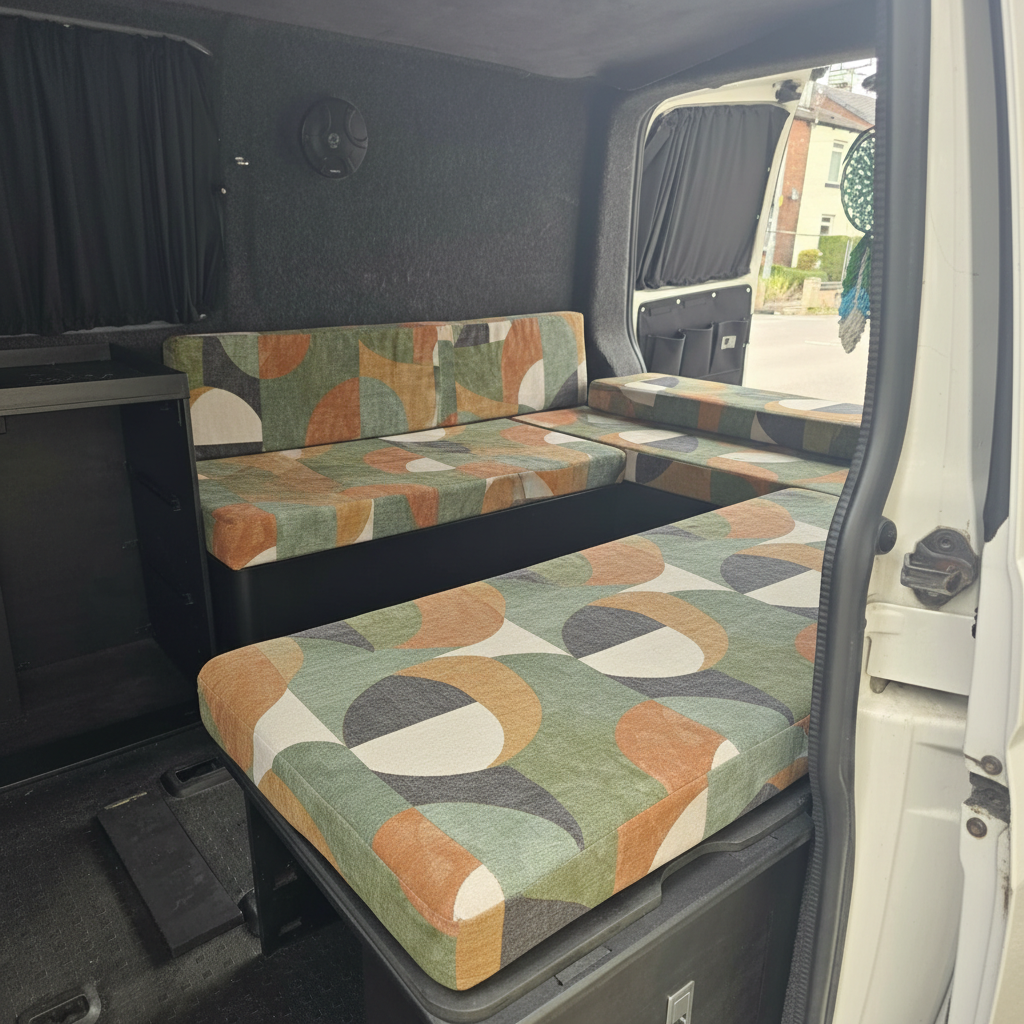 Premium campervan cushion seating with retro earth tone geometric pattern on a slide out bed
