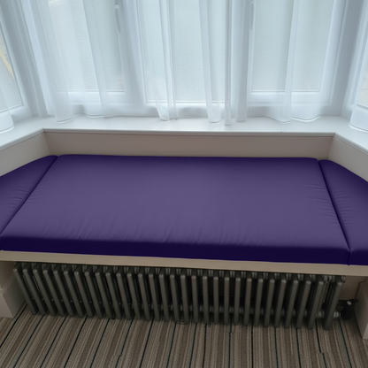 Three-piece purple bay window seat cushions neatly arranged